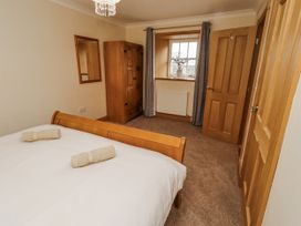 A bedroom with a bed and wardrobe at High Hemmel House in Embleton