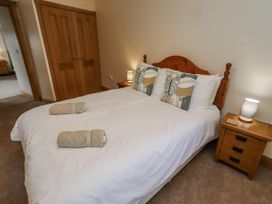 A bedroom with a bed and bedside tables at High Hemmel House in Embleton