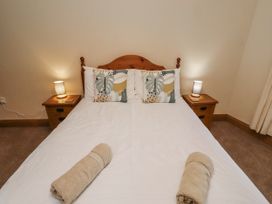 A bedroom with a bed and bedside tables at High Hemmel House in Embleton