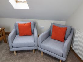 Two armchairs with orange cushions in a living room at High Hemmel House Embleton