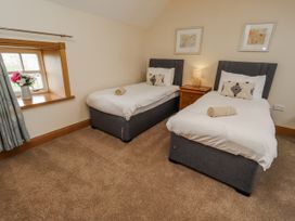 A bedroom with two beds and a window at High Hemmel House in Embleton