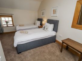 A bedroom with twin beds and a bedside table at High Hemmel House in Embleton