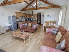 A living room with sofa and kitchen area at Home Stead Cottage in Embleton
