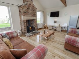 A living room with a fireplace and sofa at Home Stead Cottage in Embleton