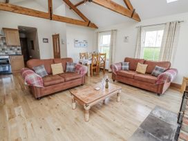 A living room with sofas and a wooden table at Home Stead Cottage in Embleton