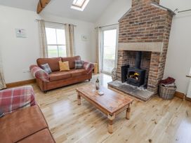 A living room with a fireplace and a sofa at Home Stead Cottage in Embleton