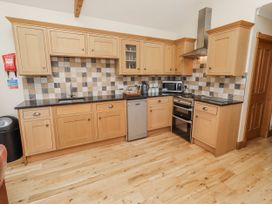 A kitchen with cabinets and appliances at Home Stead Cottage in Embleton