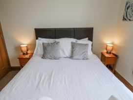 A bedroom with a bed and bedside tables at Home Stead Cottage in Embleton