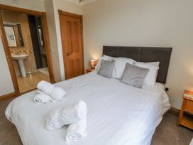 A bedroom with a bed and a bathroom view at Home Stead Cottage in Embleton