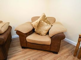 An armchair with cushions in a living room at La Rochelle in Whitby