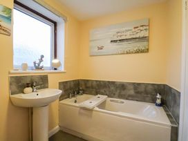 A bathroom with a bathtub and sink at La Rochelle in Whitby