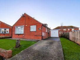 A bungalow with a driveway and garage at La Rochelle in Whitby