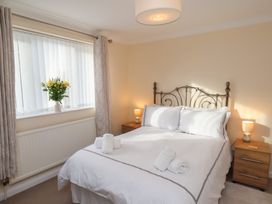 A bedroom with a bed and flowers on the window sill at La Rochelle in Whitby