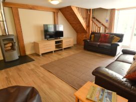 A living room with a sofa and television at Kingfisher in Blaenwaun