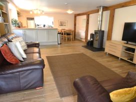 A living room with sofas, a television, and a fireplace at Kingfisher in Blaenwaun