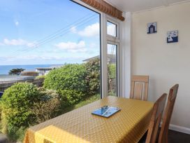 A dining room with a table and chairs at Highdown in Bigbury on Sea near Modbury