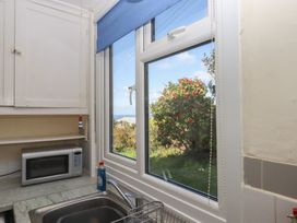 A kitchen with a window and a microwave at Highdown in Bigbury on Sea near Modbury