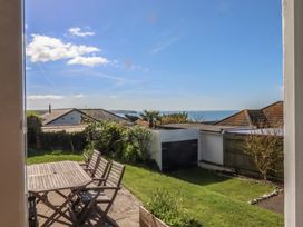 A garden with a table and chairs overlooking the sea at Highdown Bigbury on Sea near Modbury