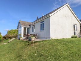 A house with windows and a seating area at Highdown in Bigbury on Sea near Modbury