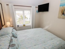 A bedroom with a bed and a television at Sandyhill House in Saundersfoot