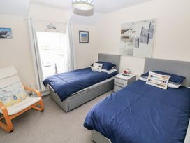 A bedroom with two beds and a bedside table at Sandyhill House in Saundersfoot