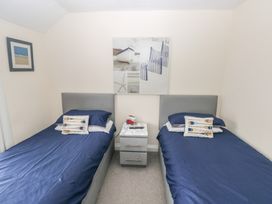 A bedroom with twin beds and a nightstand at Sandyhill House in Saundersfoot
