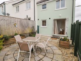 A garden with a table and chairs at Sandyhill House Saundersfoot