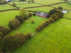 An aerial view of a house and farm surrounded by fields at Bwthyn Ty Newydd Llangadfan