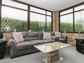 A conservatory with a sofa and coffee table at Seacrest Lodge in Scarborough