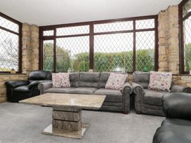 A conservatory with a sofa and coffee table at Seacrest Lodge in Scarborough