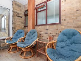 A conservatory with rocking chairs and a table at Seacrest Lodge in Scarborough