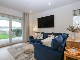 A living room with a blue sofa and television at Estuary View in Colwyn Bay