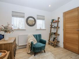 A snug with an armchair and shelving unit at Estuary View in Colwyn Bay