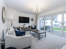 A living room with a television and sofa at Estuary View in Colwyn Bay