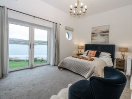 A bedroom with a bed and windows at Estuary View in Colwyn Bay