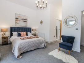 A bedroom with a bed and a chair at Estuary View in Colwyn Bay