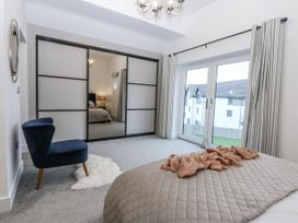 A bedroom with a bed and a chair at Estuary View in Colwyn Bay