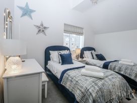 A bedroom with twin beds and a lamp at Estuary View in Colwyn Bay