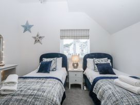 A bedroom with two beds and a window at Estuary View in Colwyn Bay