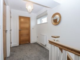 A hallway with a wooden door and a mirror at Estuary View in Colwyn Bay