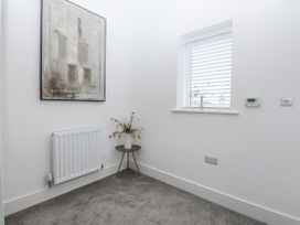 A small room with a table and a vase at Estuary View in Colwyn Bay