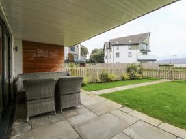 A patio with furniture and grass area at Estuary View in Colwyn Bay