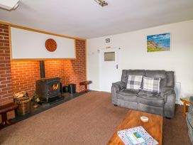 A living room with a fireplace and a sofa at Curradoon House, Touraneena, County Waterford