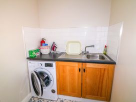 A laundry room with a washing machine and sink at Curradoon House, Touraneena, County Waterford
