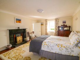 A bedroom with a bed and a fireplace at Curradoon House, Touraneena, County Waterford