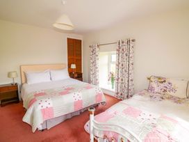 A bedroom with two beds and a window at Curradoon House in Touraneena, County Waterford