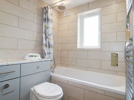 A bathroom with a bathtub shower combination and a toilet at The Beach House in Porth near Newquay