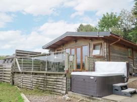 An outdoor area with a wooden cabin and hot tub at The Cabin Pontardawe