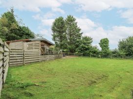 A cabin with a patio and grass area at The Cabin in Pontardawe