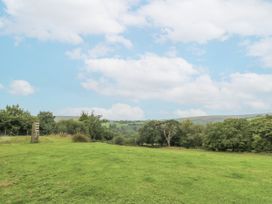A green field with trees and hills at The Cabin in Pontardawe